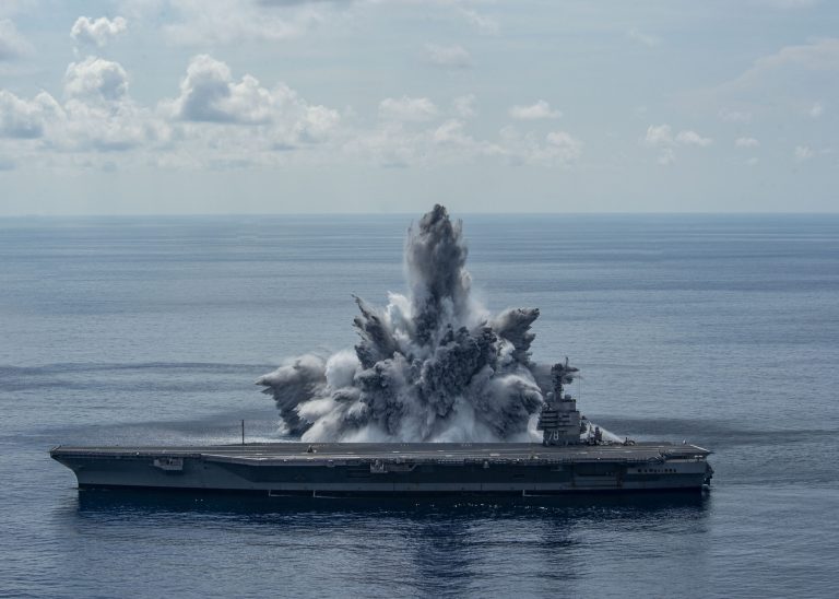 The Americans are mercilessly testing a nuclear-powered aircraft carrier.  Explosion right next to the ship