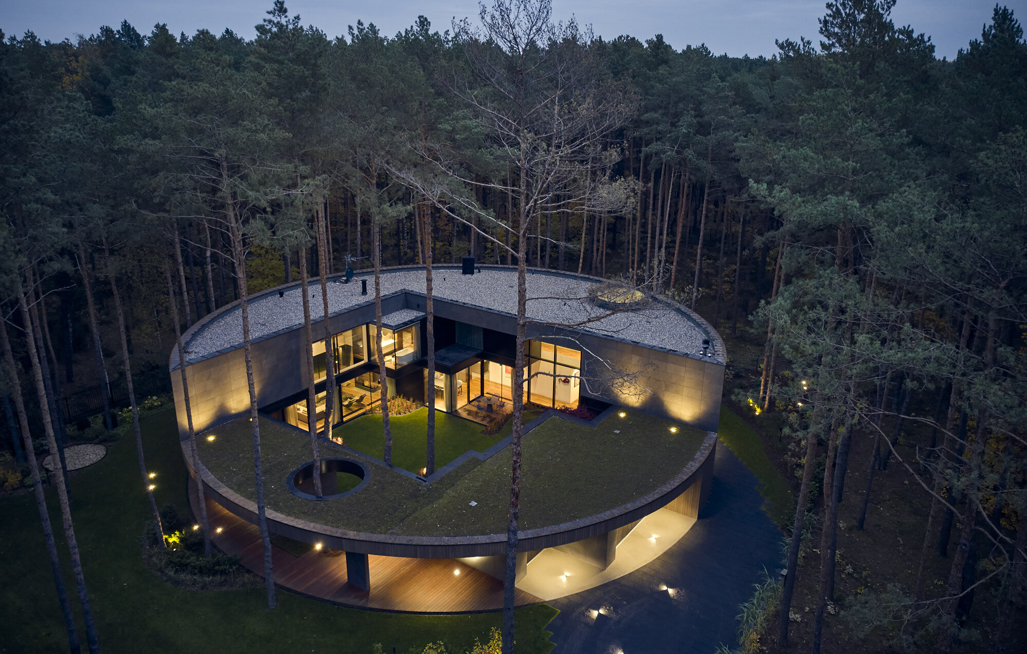 A house resembling a tree trunk.  See an unusual, round building in the heart of the forest